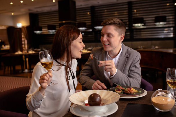 Pruébalo pareja comer deliciosa comida en el restaurante
 - Foto, imagen