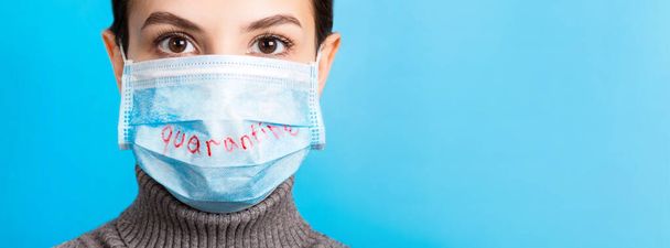 Retrato de una mujer con máscara médica con palabra de cuarentena china en el fondo azul. Coronavirus y banner de concepto de salud
. - Foto, Imagen