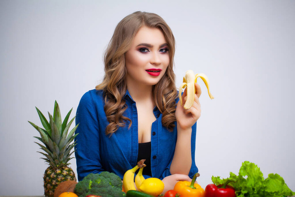 Concept of diet and healthy eating woman with vegetables on white wall background - Фото, зображення
