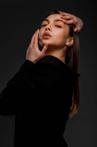 Body shot of a beauty modern girl wearing black top against grey background - 写真・画像