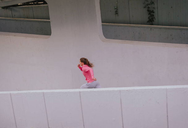 Corredor feminino saudável jovem durante uma rotina de exercícios urbanos - Foto, Imagem