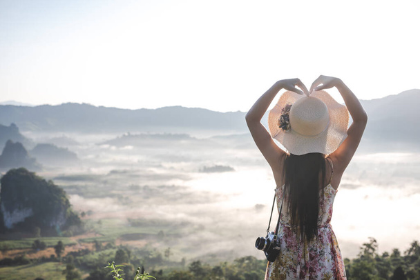 Women show heart-shaped gestures at the viewpoint on the mountai - Foto, Imagen