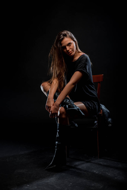 Portrait of an attractive trendy girl in leather knee hig boots and black tunic - Zdjęcie, obraz