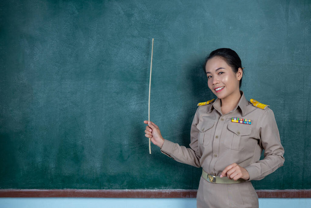 thai teacher in official outfit  teaching in front of  backboard - Photo, Image
