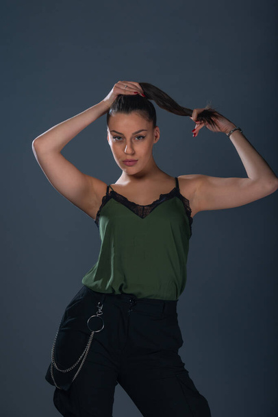 Fashion sexy picture of an attractive woman posing while  holding her ponytail - Фото, зображення