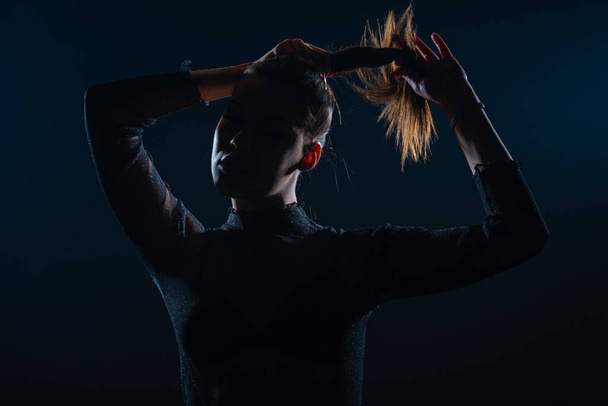 Dark contrast portrait of beautiful young woman with ponytail hairstyle - Photo, Image