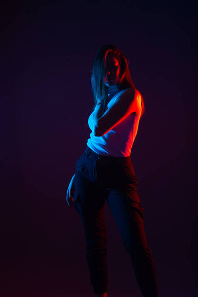 Blue and red light portrait of a female model on a black background with high contrast - Fotoğraf, Görsel