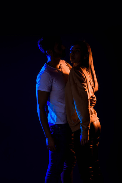 Modeaufnahme aus dem Studio: leidenschaftlicher Typ und Mädchen kuscheln zusammen - Foto, Bild