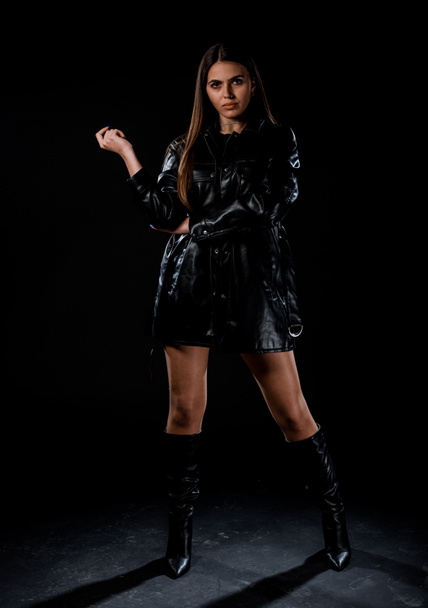 Portrait of an attractive young woman dressed in black leather stylish clothing - 写真・画像