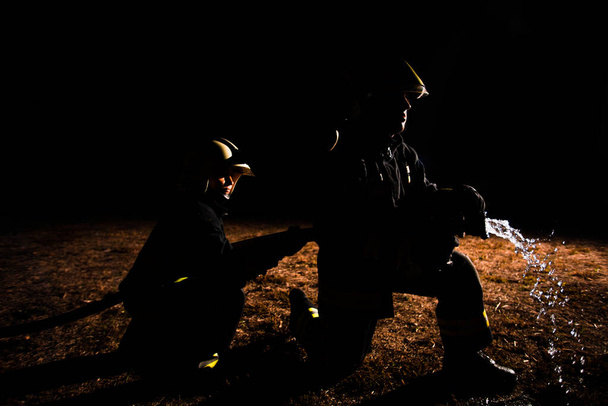 Πυροσβέστες εξοπλισμένοι με εργαλεία κατά τη διάρκεια επιχείρησης πυρόσβεσης - Φωτογραφία, εικόνα