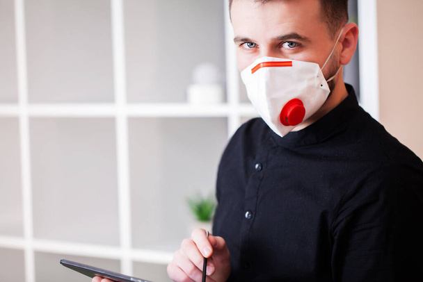 Uomo che lavora in ufficio indossando una maschera per la protezione dal coronavirus
 - Foto, immagini