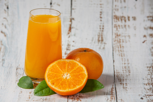 Sumo de laranja fresco num copo e laranja fresca - Foto, Imagem