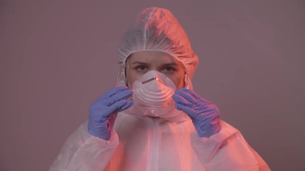 Professionele vrouwelijke arts in masker staat in het ziekenhuis kamer zetten bril op. Gezondheidszorgconcept. Laboratoriummedewerker - Video