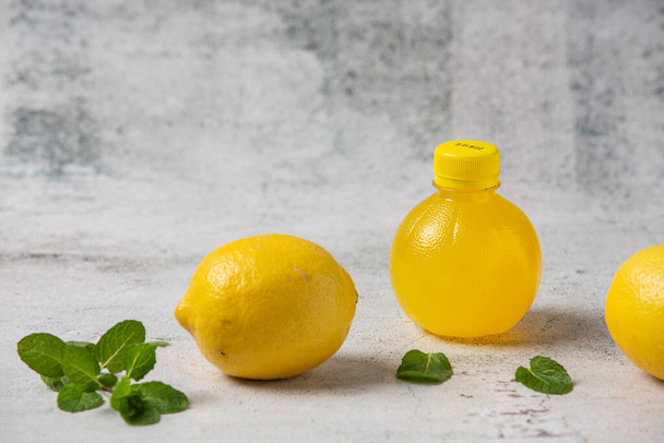 Εμφιαλωμένο χυμό λεμονιού και φρέσκα προϊόντα λεμονιού - Φωτογραφία, εικόνα