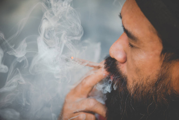 closed up mustache man smoke marijuanna joint  - Фото, зображення