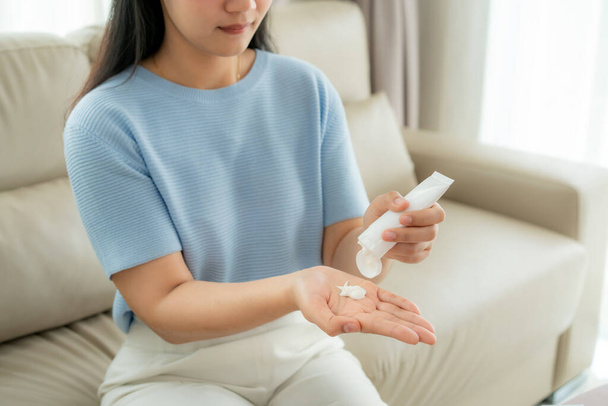 Ázsiai nő használ krémet, vagy hidratálja a kezét a mindennapi élet védelme érdekében bőr száraz és irritált használata után alkoholos fertőtlenítő gél, megelőzés, tisztító kéz fertőzés. - Fotó, kép