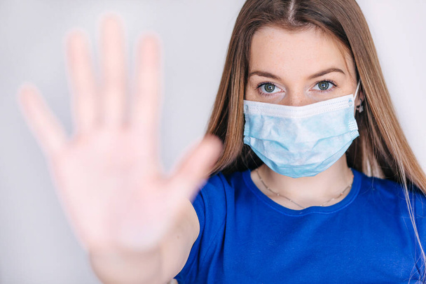 Koncepcja Covid-19 i zanieczyszczenia powietrza pm2.5. Młoda kobieta w masce do ochrony koronawirusa i pokazać gest zatrzymania rąk, aby zatrzymać wybuch wirusa korony.covid19 objawy epidemii koronawirusa. - Zdjęcie, obraz