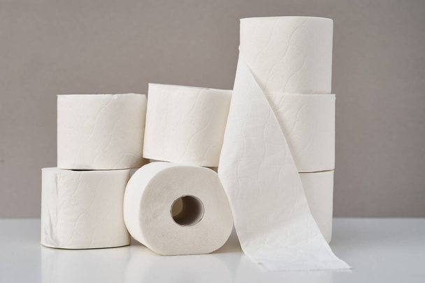 Gestapelte Toilettenpapierrollen auf grauem Hintergrund. Hygienekonzept - Foto, Bild