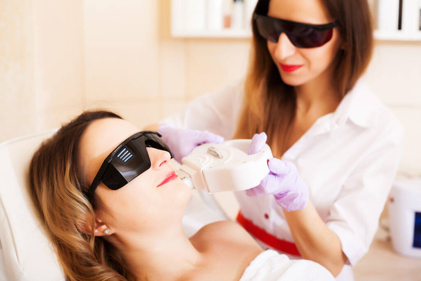 Žena dělá laserové odstranění vlasů v kosmetickém studiu - Fotografie, Obrázek