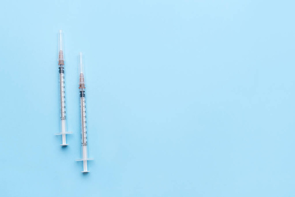 Duas seringas para injeção em mesa azul no hospital
. - Foto, Imagem