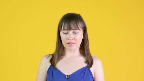 A young girl puts on a medical mask. Isolated on a yellow background. health care and medical concept. - Video