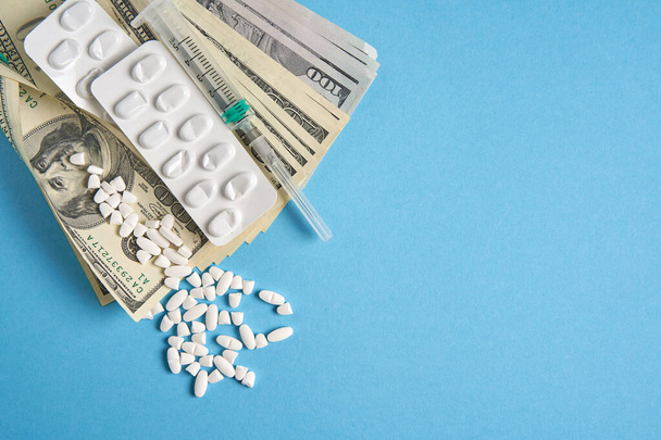 pills empty blisters for drugs individual syringe and money lie on a blue background Expensive medicine health insurance concept. Expensive treatment of diseases. Budget for medical expenses. - Foto, Imagen