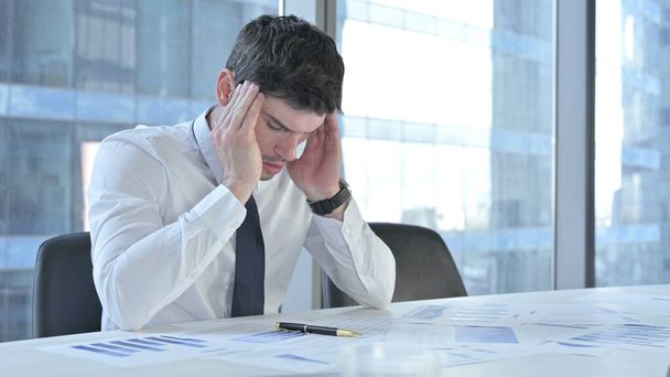 Müder Geschäftsmann hat Kopfschmerzen bei der Arbeit am Schreibtisch - Foto, Bild