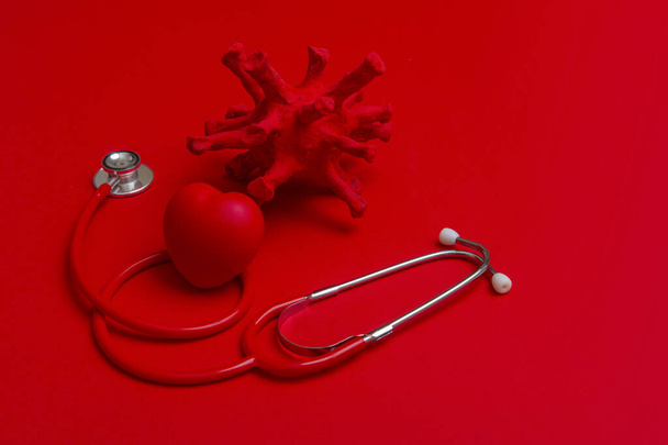 要約ウイルス株モデル,赤の背景に心臓と聴診器.コロナウイルスの隔離。ウイルスの流行保護の概念 - 写真・画像