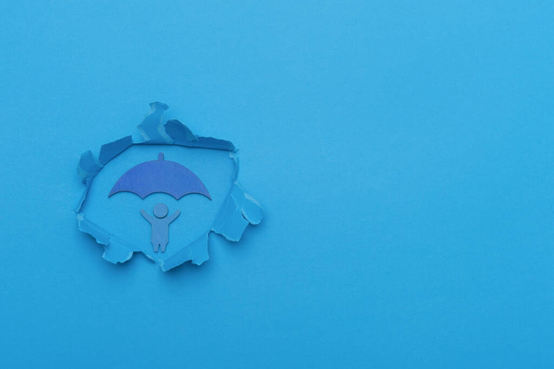 Conceito do Dia Mundial da Consciência do Autismo. A criança tem uma forma de guarda-chuva no furo de corte de papel
 - Foto, Imagem