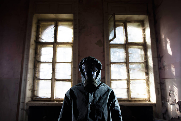 Post apocalyptic survivor in gas mask in a ruined building. Environmental disaster, armageddon concept. - Foto, Imagen