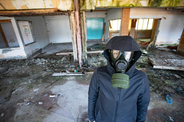 Post apocalyptic survivor in gas mask in a ruined building. Environmental disaster, armageddon concept. - Zdjęcie, obraz