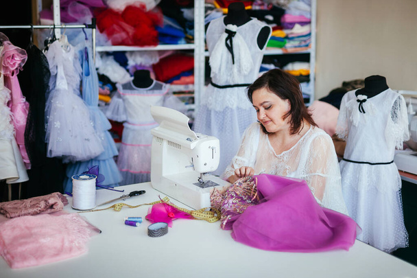 adult woman seamstress sews dress - Photo, image