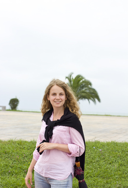 La hermosa rubia con el pelo rizado en la playa. estilo country
 - Foto, Imagen