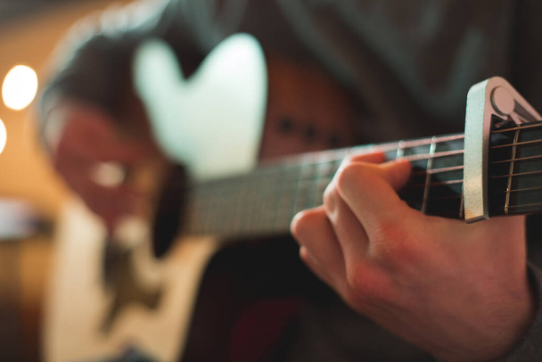 Młody człowiek gra na gitarze akustycznej - Zdjęcie, obraz