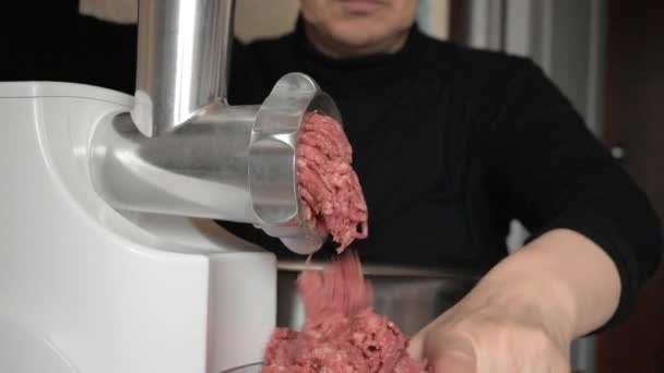 Usando una picadora de carne, la carne en masa se muele en carne picada
. - Metraje, vídeo