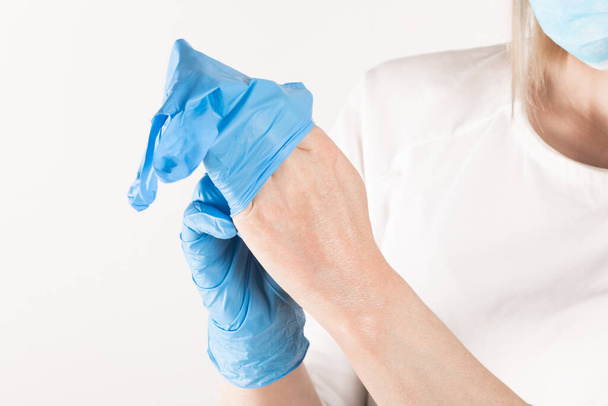 Woman puts on medical gloves close up. - Foto, imagen