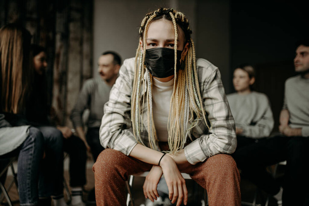 ill caucasian woman sit in the mask - Фото, изображение