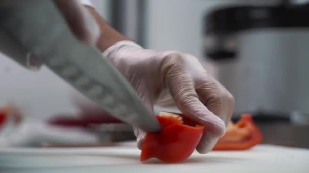 Cook cuts red pepper on the kitchen table. Close-up. - Video, Çekim