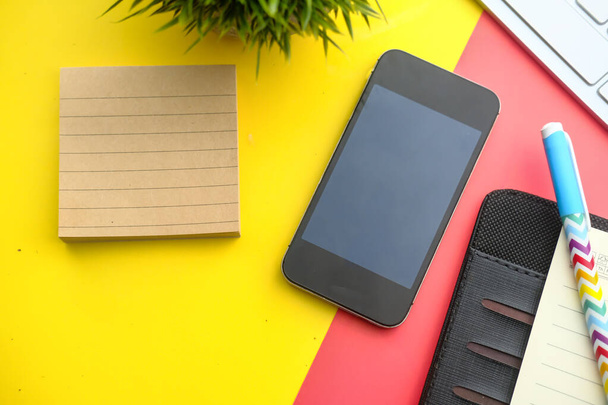 Blank screen cellphone on diagonal pastel yellow and red background. - Φωτογραφία, εικόνα