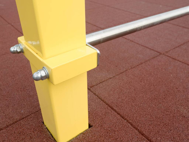 Quadro para escada sueca de metal com vigas amarelas sobre fundo escuro ablurred. Equipamentos esportivos modernos, ffitness, ginástica, musculação formação em ambientes fechados
. - Foto, Imagem
