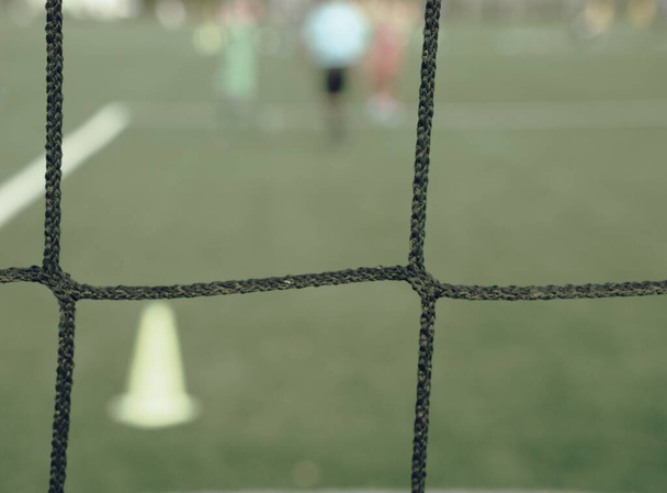 サッカーの試合中にサッカーゲートネットを介して表示されます。ゴールキーパーゲートラインの前で待ちます - 写真・画像