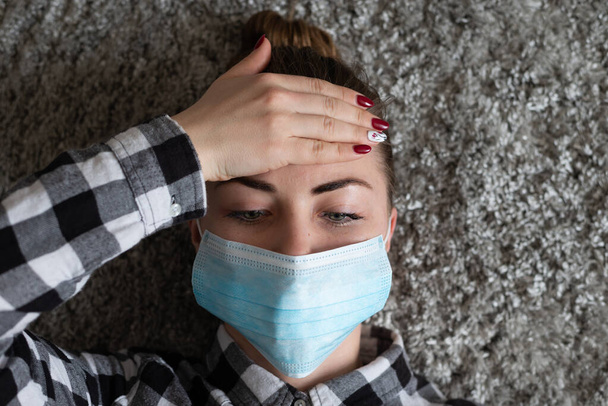 Girl with medical mask to protect her from virus. Coronavirus pandemic. Woman with mask standing . People being hospitalized, diagnosed, often put in carantine (isolation) to stop spreading Corona. - 写真・画像