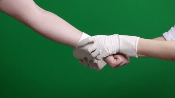 Női ápolónő bekötözte a férfi páciens kezét. Zöld háttér. Kroma kulcs. - Felvétel, videó