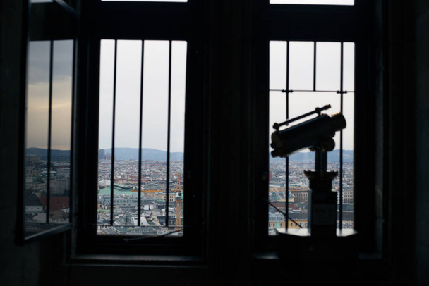 Ένας άντρας κοιτάζει έξω από το παράθυρο από το παρατηρητήριο. - Φωτογραφία, εικόνα