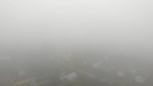 Πυκνή ομίχλη πάνω από την πόλη. Συνθήκες που αυξάνουν τον κίνδυνο ατυχημάτων στο δρόμο. Θέμα καιρικών συνθηκών και φυσικών στοιχείων. Αεροσκάφος 4K κινηματογραφικό υλικό - Πλάνα, βίντεο
