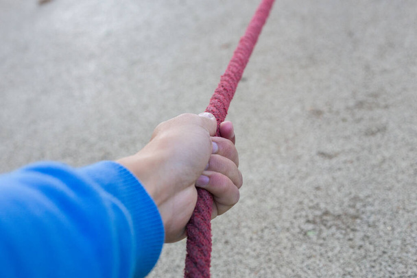 Mužská ruka drží červené lano - Fotografie, Obrázek