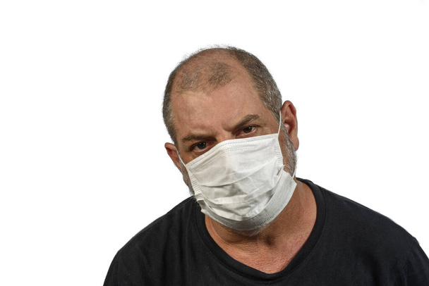 医者のマスクの男の肖像画。高齢者のためのCOVID-19コロナウイルスの危険性の概念.白い背景にテキストのスペースがあり - 写真・画像