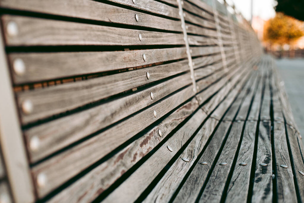 Wooden bench in the city in autumn - Фото, изображение