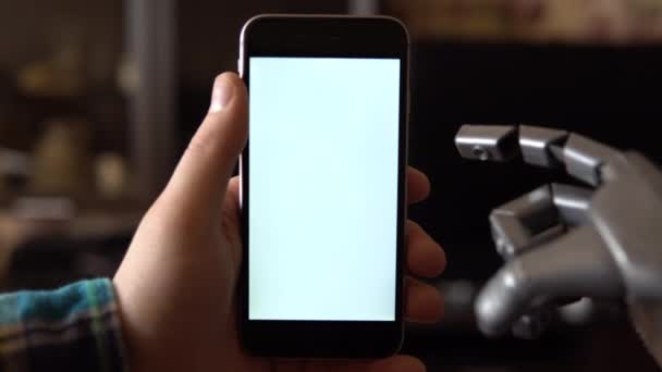 Cyborg uses the phone. Gray mechanical hand swipe right on smartphone with white screen. Template. - Footage, Video