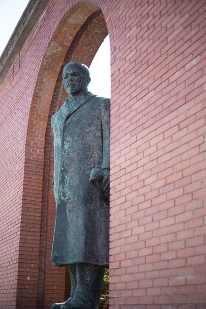 Estatua de Lenin monumento viejo cerca de una pared de ladrillo
 - Foto, Imagen